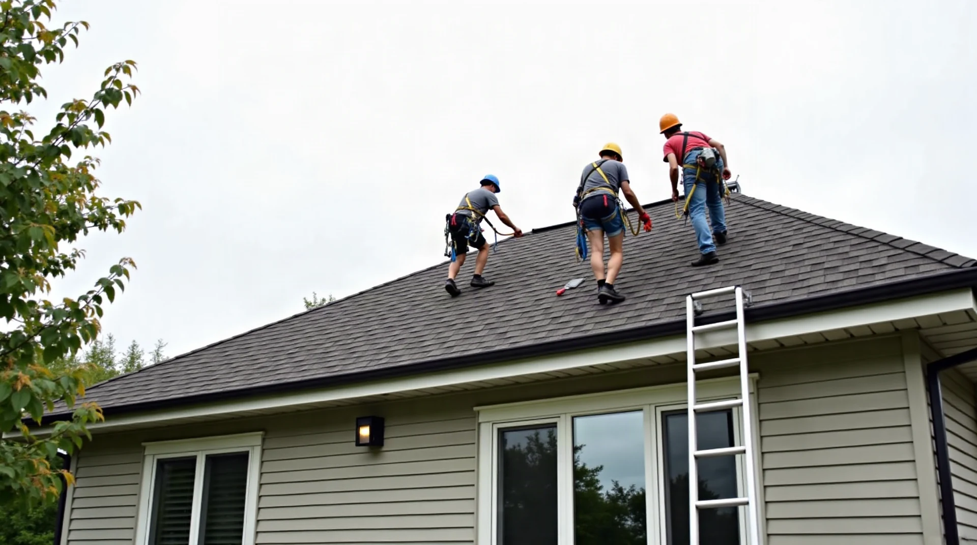 Wide photograph of a small roofing crew in safety harnesses working on a suburban house roof, people small in frame, overcast sky